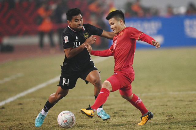 Pemain Timnas Indonesia Asnawi Mangkualam (kiri) berusaha melewati pemain Timnas Vietnam Nguyen Quang Hai dalam pertandingan leg 2 babak semifinal Piala AFF 2022 di Stadion Nasional My Dinh, Hanoi, Vietnam, Senin (9/1/2023). Foto: Aditya Pradana Putra/ANTARA FOTO
