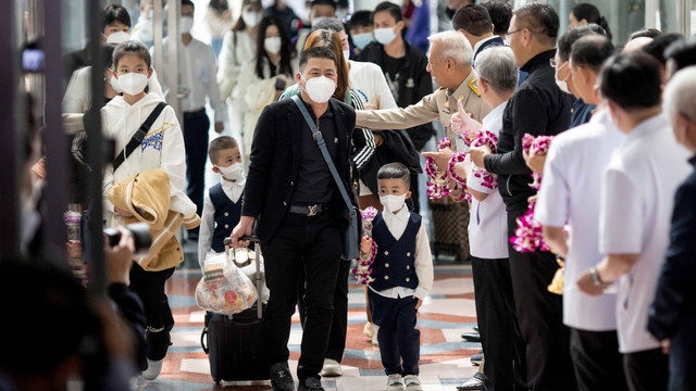 Wisatawan dari penerbangan Xiamen Airlines disambut oleh pejabat kesehatan dan pemerintah Thailand saat mereka tiba di Bandara Suvarnabhumi di Bangkok, Senin (9/1/2023). Foto: Jack Taylor/AFP