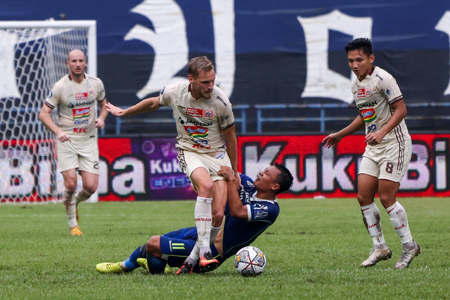 Pemain Persib Bandung Dedi Kusnandar (tengah) berebut bola dengan pemain Persija Jakarta Hanno Behrens (kiri) saat menjalani laga tunda BRI Liga 1 di Stadion Gelora Bandung Lautan Api, Bandung, Jawa Barat, Rabu (11/1/2023).  Foto: Raisan Al Farisi/ANTARA FOTO