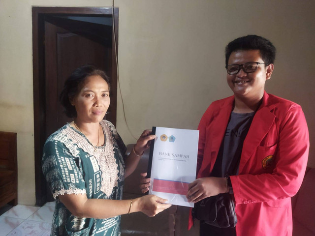 Salah satu mahasiswa meberikan buku langkah-langkah pendirian bank sampah