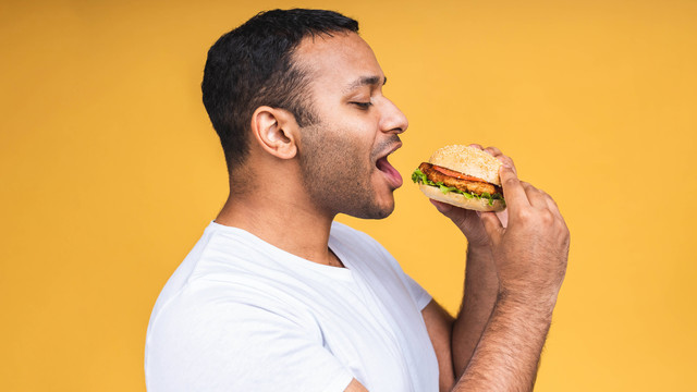Ilustrasi makan burger. Foto: Oksana Kyrychenko/Shutterstock