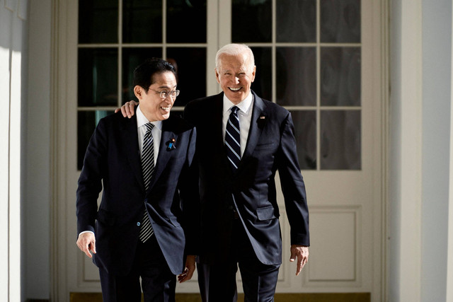 Presiden AS Joe Biden dan Perdana Menteri Jepang Fumio Kishida berjalan melewati barisan tiang menuju Oval Office di Gedung Putih di Washington, AS, Jumat (13/1/2023). Foto: T.J. Kirkpatrick/Pool via REUTERS