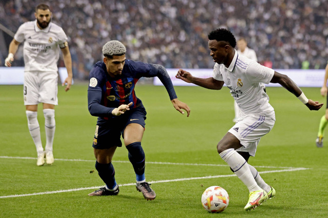 Pemain FC Barcelona Ronald Araujo berusaha menghadang pemain Real Madrid Vinicius Junior pada pertandingan Piala Piala Super Spanyol di Stadion Internasional King Fahd di Riyadh, Arab Saudi. Foto: Ahmed Yosri/REUTERS