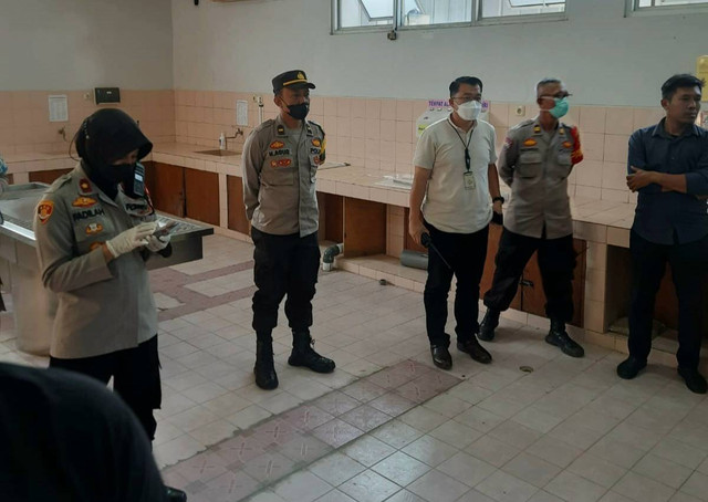 Petugas kepolisian saat mengevakuasi jenazah korban ke rumah sakit. (ist)