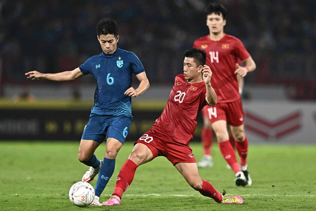 Sarach Yooyen (Kiri) dari Thailand dan Phan Van Duc dari Vietnam (depan kanan) memperebutkan bola pada leg kedua pertandingan sepak bola final Piala AFF antara Vietnam dan Thailand di Stadion Thammasat di Bangkok pada 16 Januari 2023. Foto: Lillian SUWANRUMPHA/AFP