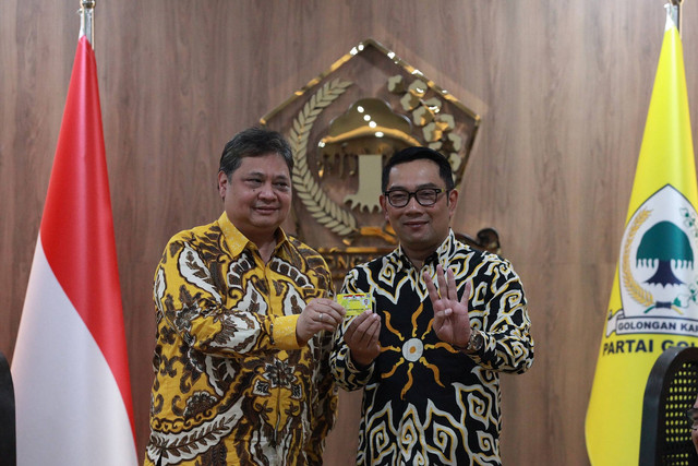 Ketua Umum Partai Golkar Airlangga Hartanto (kiri) menyerahkan KTA Partai Golkar pada Gubernur Jawa Barat Ridwan Kamil saat pertemuan Partai Golkar di Kantor DPP Partai Golkar, Jakarta, Rabu (18/1/2023). Foto: Reno Esnir/Antara Foto