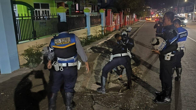 Dinas Perhubungan Kota Palu membersihkan tumpukan material pasir yang berhamburan di bahu jalan di depan Sekolah Dasar Inpres 1 Lolu, Jalan Kartini, Kota Palu, pada Jumat malam (20/1). Foto: Istimewa