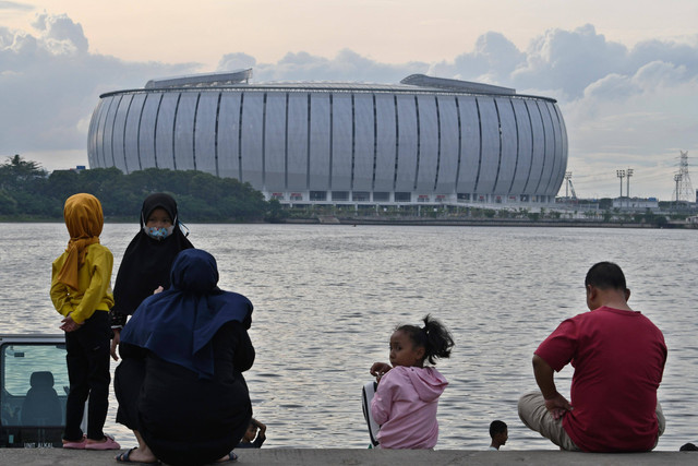 Sejumlah warga menikmati suasana di Danau Cincin dengan berlatar belakang Jakarta International Stadium (JIS) di Papanggo, Tanjung Priok, Jakarta, Senin (23/1/2023). Foto: Aditya Pradana Putra/ANTARA FOTO