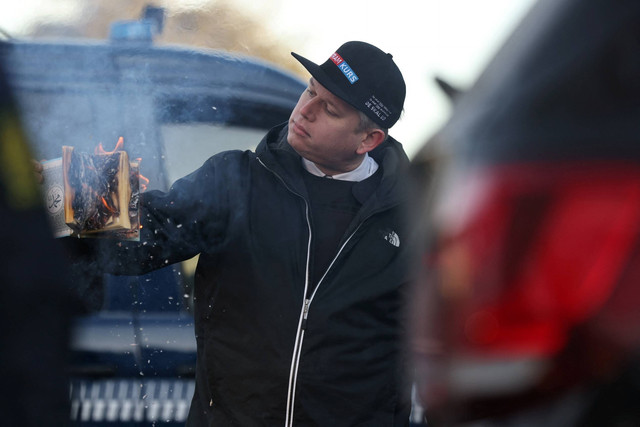Politisi sayap kanan Rasmus Paludan membakar salinan Al-quran saat protes di depan kedutaan Turki di Kopenhagen, Denmark, Jumat (27/1/2023). Foto: Ritzau Scanpix/Olafur Steinar Gestsson via REUTERS