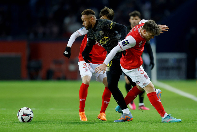Pemain Paris St Germain Neymar beraksi dengan pemain Stade de Reims 'Junya Ito dan Thomas Foket di Parc des Princes, Paris, Prancis , Minggu (29/1/2023) Foto: Christian Hartmann/REUTERS