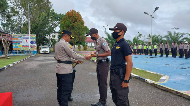 Kapolres Sekadau, AKBP Suyono, menyerahkan penghargaan kepada Satpam. Foto: Dina Mariana/Hi!Pontianak