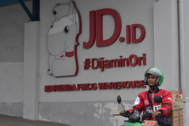 Seorang pekerja mengendarai sepeda motor melintas di depan gudang JD.ID, Kabupaten Bekasi, Jawa Barat, Selasa (31/1/2023). Foto: ANTARA FOTO/Fakhri Hermansyah