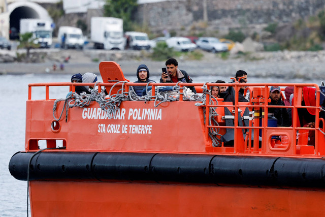Migran menunggu untuk turun dari kapal penjaga pantai Spanyol, di pelabuhan Arguineguin, di pulau Gran Canaria, Spanyol. Foto: Borja Suarez/REUTERS