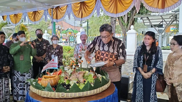 Sekda Kota Yogyakarta, Aman Yuriadijaya, saat memotong tunpeng untuk rayakan 1 tahun Teras Malioboro, Selasa (7/2/2023). Foto: Maria Wulan/Tugu Jogja