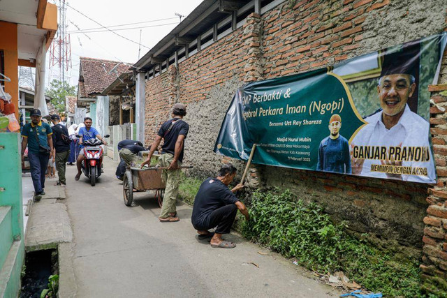 Ganjar Muda Padjadjaran (GMP) bersama anak muda Dusun Turisari, Desa Mekarmaya, Kec. Cilamaya Wetan, Karawang bergotong royong bersihkan jalanan hingga selokan, Selasa (7/2/23). Foto: Dok. Istimewa