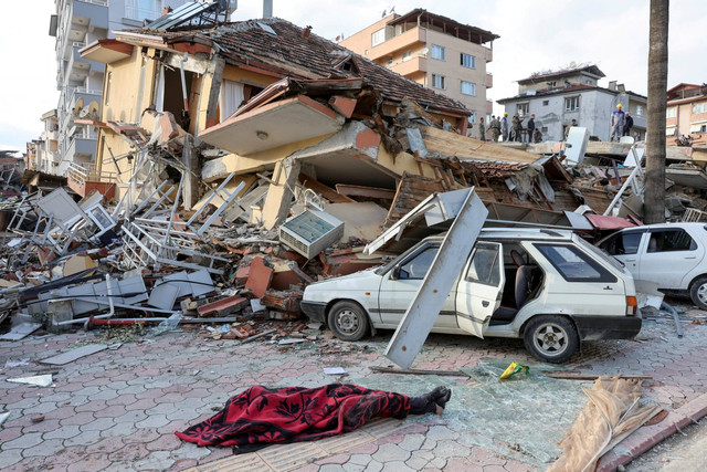 Mayat tergeletak di tanah dekat puing-puing, menyusul gempa bumi di Provinsi Hatay, Turki, Selasa (7/2/2023) Foto: Umit Bektas/REUTERS