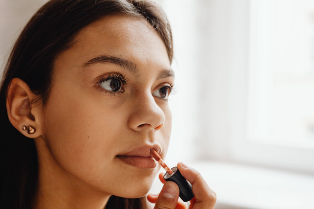 Ilustrasi seseorang mencoba warna lipstik Wardah agar wajah terlihat cerah. Foto: Pexels.com