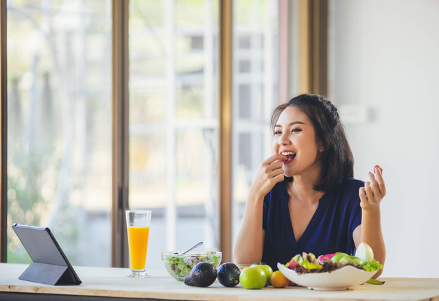 Ilustrasi perempuan makan buah. Foto: Shutterstock