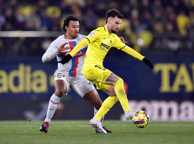 Alex Baena dari Villarreal duel dengan Jules Kounde dari FC Barcelona di Estadio de la Ceramica, Villarreal, Spanyol. Foto: Pablo Morano/Reuters