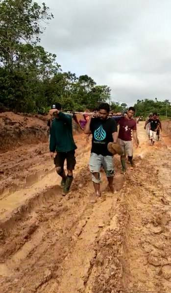 Warga Desa Semabi, Kalbar, menandu orang sakit melewati jalan yang rusak. Foto: Dok. Istimewa