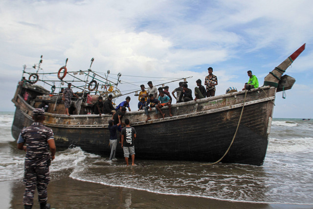 Personel TNI mengawal imigran etnis Rohingya yang terdampar di Desa Lampanah Leugah, Kecamatan Seulimeuem, Aceh Besar, Aceh, Kamis (16/2/2023). Foto: Ampelsa/ANTARA FOTO
