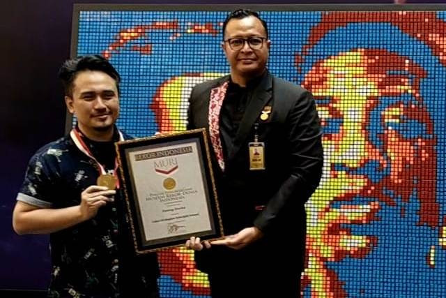 Denny Darko terima rekor MURI buat lukisan dengan kubik rubik terbanyak.
Foto: Alexander Vito/kumparan
