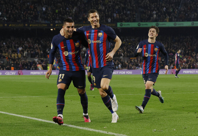 Robert Lewandowski merayakan gol kedua Barcelona bersama Ferran Torres dan Gavi  kala menjamu Cadiz dalam lanjutan Liga Spanyol 2022/23 di Stadion Camp Nou, Senin (20/2). Foto: Albert Gea/REUTERS