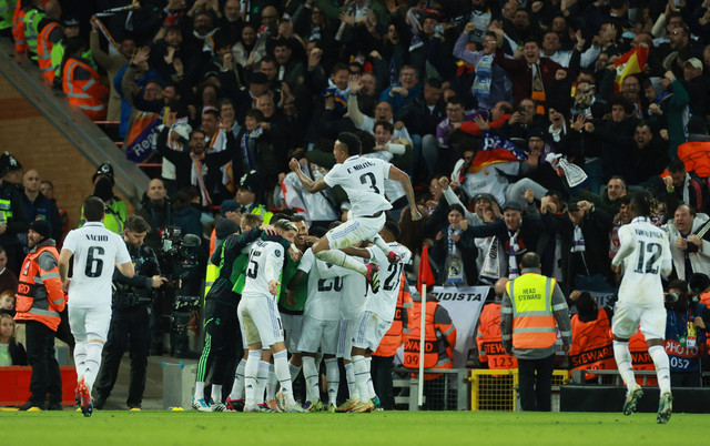 Para pemain Real Madrid merayakan gol kelima yang dicetak Karim Benzema kala bertandang ke markas Liverpool di babak 16 besar Liga Champions 2022/23 di Stadion Anfield, Selasa (22/2). Foto: Phil Noble/REUTERS