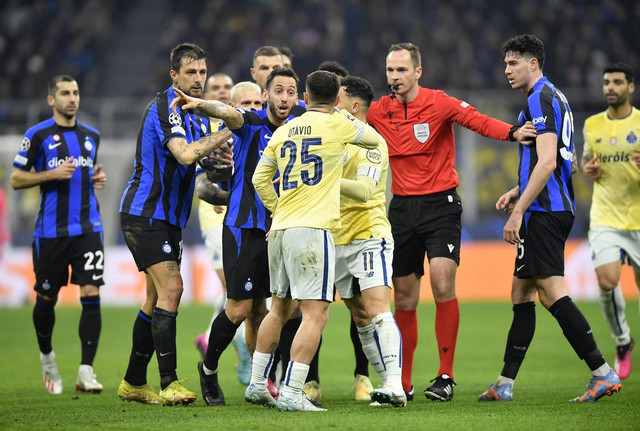 Pemain Inter Milan, Hakan Calhanoglu, beradu argumen dengan pemain FC Porto, Otavio, dalam pertandingan leg pertama babak 16 besar Liga Champions 2022/23 di Stadion San Siro, Kamis (23/3). Foto: Daniele Mascolo/REUTERS