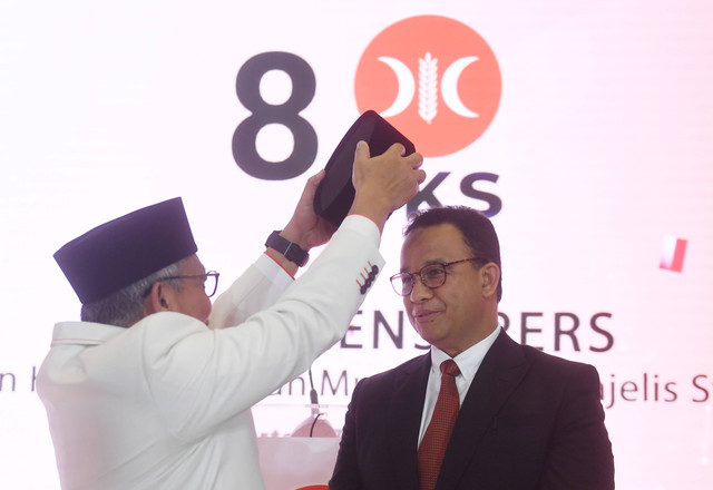 Presiden PKS Ahmad Syaikhu (kiri) menyematkan peci kepada mantan Gubernur DKI Jakarta Anies Rasyid Baswedan (kanan) sebagai tanda dukungan sebagai bakal calon presiden 2024-2029 usai pembacaan hasil keputusan Musyawarah Majelis Syuro VIII PKS. Foto: Akbar Nugroho Gumay/Antara Foto