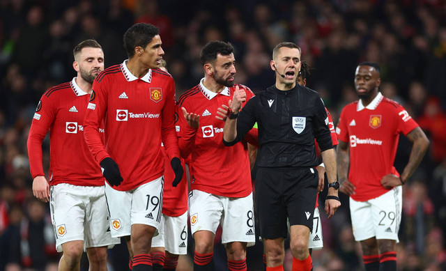 Para pemain Manchester United melakukan protes kepada wasit Clement Turpin dalam pertandingan playoff Liga Europa 2022/23 kontra Barcelona di Stadion Old Trafford, Jumat (24/2). Foto: Carl Recine/Reuters