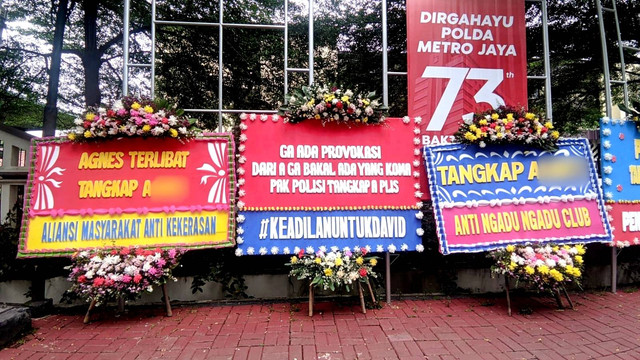 Sejumlah karangan bunga minta polisi tangkap perempuan A di kasus penganiayaan David terpasang di depan Mapolres Jaksel, Sabtu (25/2/2023). Foto: Jonathan Devin/kumparan