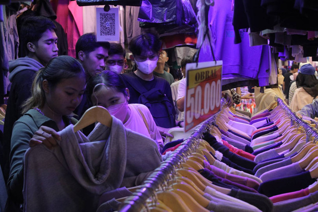 Calon pembeli memilih pakaian impor bekas di Pasar Senen, Jakarta, Minggu (26/2/2023). Foto: Iqbal Firdaus/kumparan