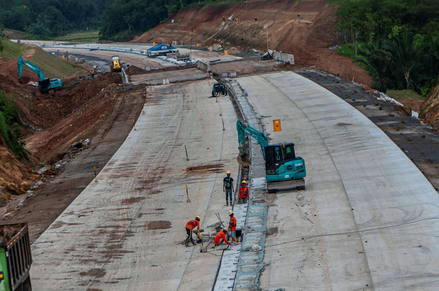Pekerja menyelesaikan proyek pembangunan jalan tol Rangkasbitung-Panimbang seksi II di Lebak, Banten, Minggu (26/2/2023).  Foto: Muhammad Bagus Khoirunas/ANTARA FOTO