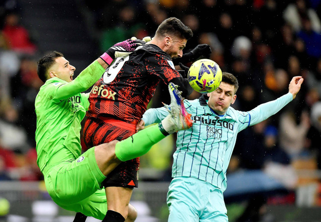 Olivier Giroud AC Milan beraksi dengan Juan Musso dan Joakim Maehle dari Atalanta di San Siro, Milan, Italia. Foto: Daniele Mascolo/Reuters