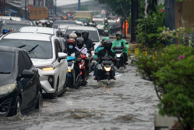 Sejumlah kendaraan melintas di jalanan tergenang banjir karena hujan deras, di kawasan kota Bekasi, Senin (27/2/2023). Foto: Iqbal Firdaus/kumparan