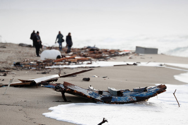 Sisa-sisa kapal terlihat di sepanjang pantai tempat jenazah para imigran Turki ditemukan setelah kapal karam, di Cutro, pantai timur wilayah Calabria Italia, Italia, Minggu (26/2/2023). Foto: Remo Casilli/REUTERS