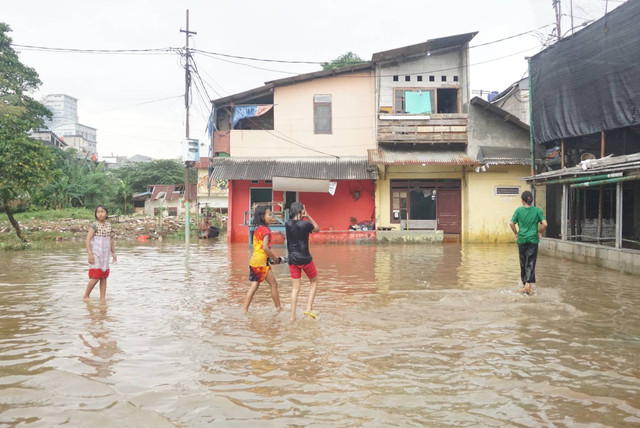 Sejumlah anak bermain saat banjir di kawasan Rawajati, Jakarta Selatan, Senin (27/2). Foto: Iqbal Firdaus/kumparan