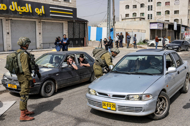 Tentara Israel melakukan penjagaan di sepanjang jalan di kota Huwara dekat Nablus di Tepi Barat, Senin (27/2/2023). Foto: Ronaldo Schemidt/AFP