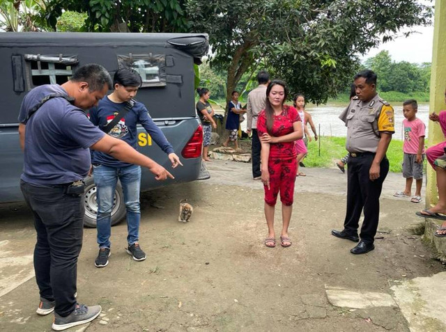 Wanita bernama Shinta (baju merah) dan polisi saat melakukan olah TKP. (ist)
