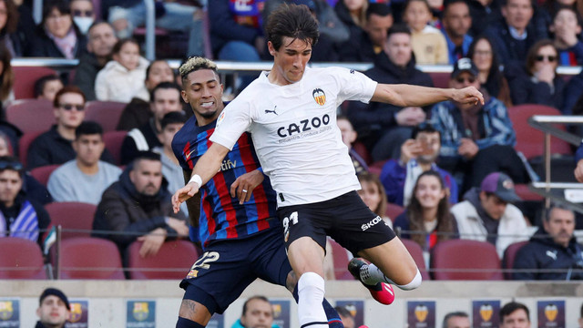 Raphinha (kiri) duel dengan Jesus Vazquez saat Barcelona melawan Valencia dalam pertandingan pekan ke-24 Liga Spanyol 2022/23 di Stadion Camp Nou pada 5 Maret 2023. Foto: REUTERS/Albert Gea