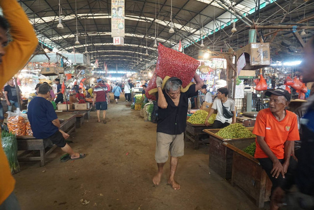 Pekerja mengangkut bawang merah di Pasar Induk Kramat Jati, Jakarta, Senin (6/3/2023). Foto: Iqbal Firdaus/kumparan
