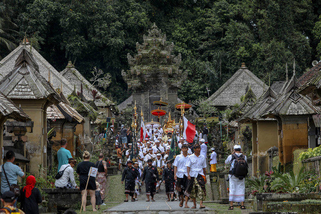 Sejumlah turis menyaksikan umat hindu melaksanakan ibadah di desa Penglipuran, Bangli, Bali, selasa (7/3/2023).  Foto: Aditia Noviansyah/kumparan