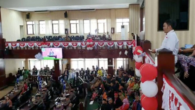 Pria menyawer uang mainan dari lantai 2 saat Plt Walikota Bekasi Tri Adhianto berada di mimbar. Foto: kumparan