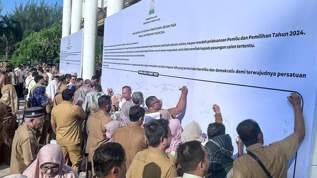 ASN menandatangani spanduk ikrar netralitas dalam Pemilu 2024. Foto: Suparta/acehkini