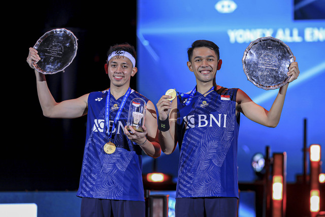 Pebulu tangkis ganda putra Indonesia Fajar Alfian (kanan) dan Muhammad Rian Ardian (kiri) berpose dengan medali dan trofinya usai menang dalam final All England 2023 di Utilita Arena Birmingham, Inggris, Minggu (19/3/2023). Foto: ANTARA FOTO/HO-Humas PBSI