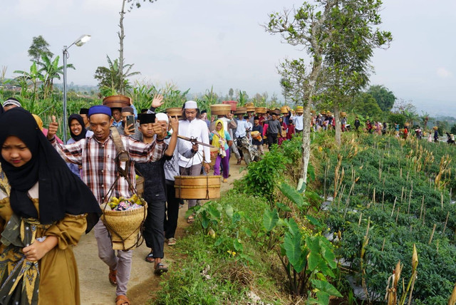 Warga Dusun Jekaton mengusung tenong usai nyadran di makam setempat Rabu (22/3/2023). Foto: ari/Tugu Jogja