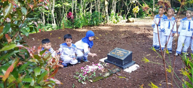 Anak-anak TK Alkautsar sedang menabur bunga di atas pusara makam pendiri yayasan