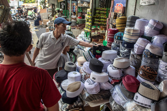 Calon pembeli memilih peci di Pasar Tanah Abang, Jakarta, Kamis (23/3/2023). Foto: Muhammad Adimaja/Antara Foto