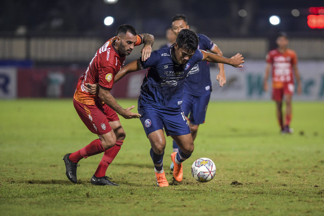 Pesepak bola Arema FC M Rafli (kanan) berusaha melewati hadangan pesepak bola Bali United Brwa Nouri (kiri) dalam lanjutan Liga 1 di Stadion PTIK, Jakarta, Senin (27/3/2023).  Foto: Galih Pradipta/Antara Foto